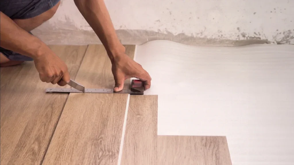 Close-up of flooring installation with underlayment layer beneath laminate or vinyl flooring, showing added support and protection.
